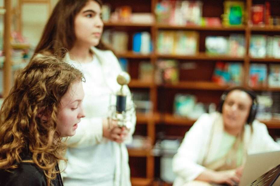 deux jeunes filles enregistrent leurs voix autour d'un micro